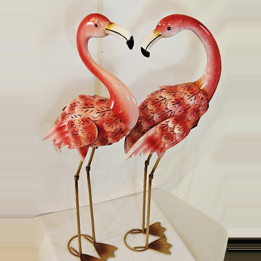 Metal flamingo statues posed to form a heart