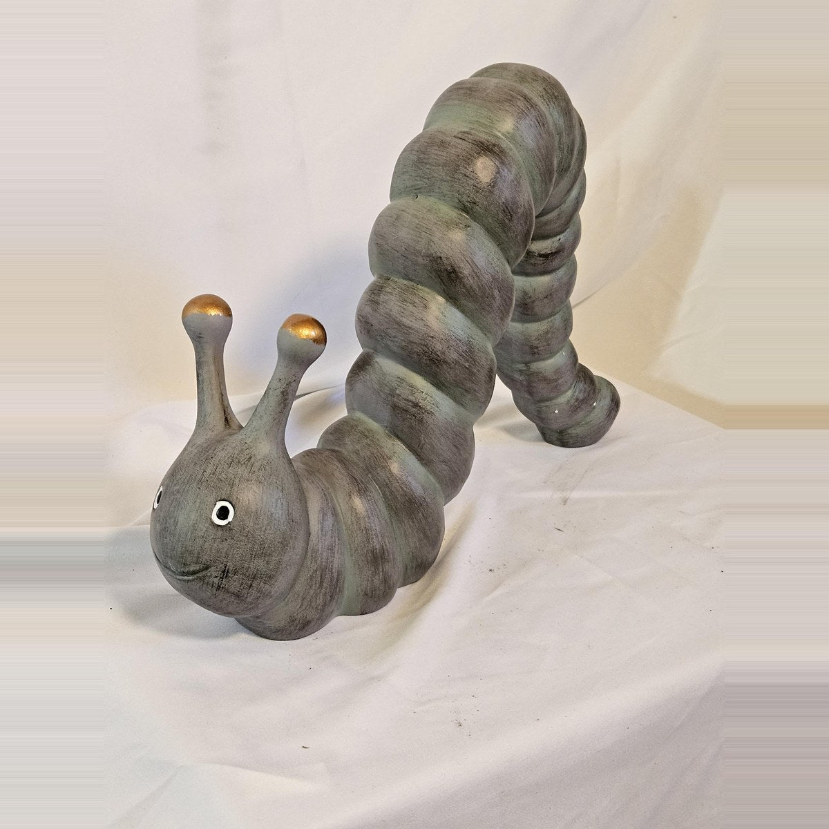 Arched inchworm caterpillar garden statue front view