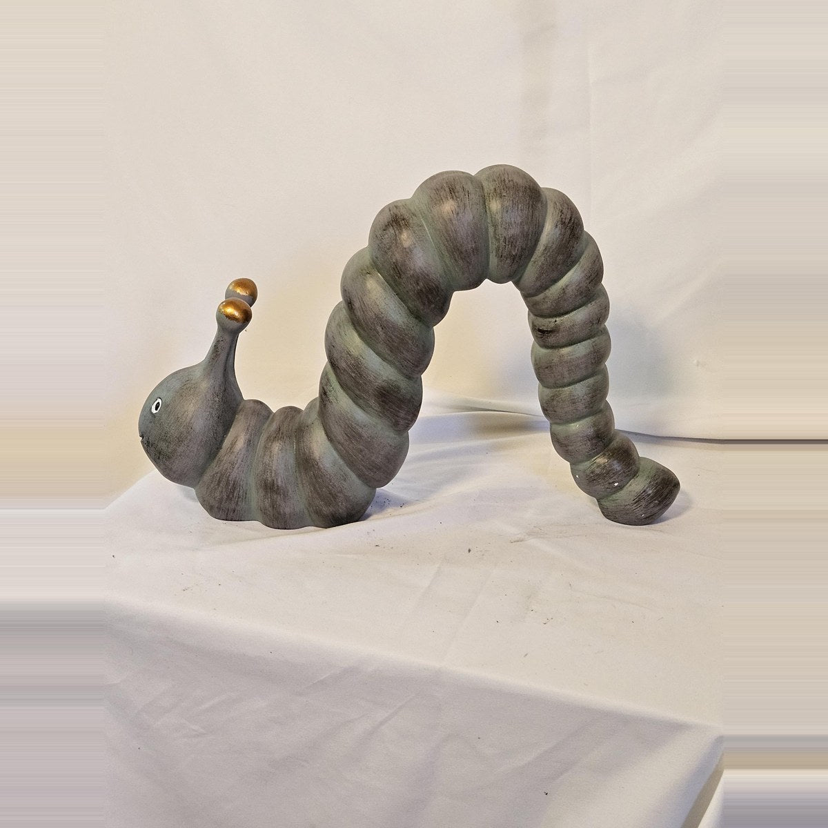 Arched inchworm caterpillar garden statue side view