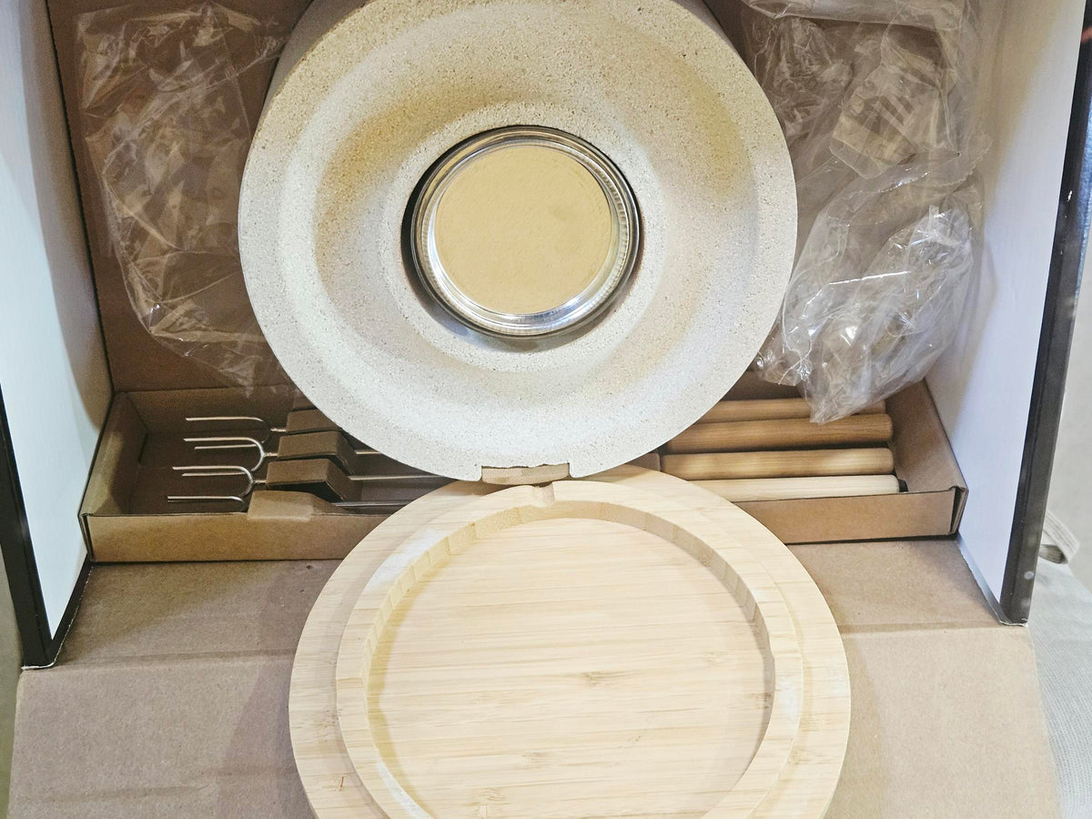 Open box showing stone fire bowl, gel fuel, bamboo lid and skewers all present