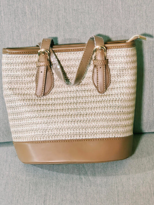 Woven straw tote bag angled view showing zip top
