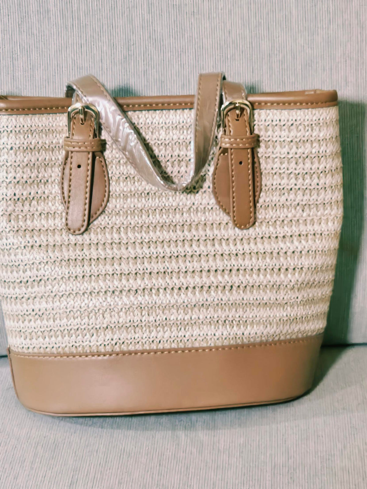 Woven straw tote bag with tan trim, front view